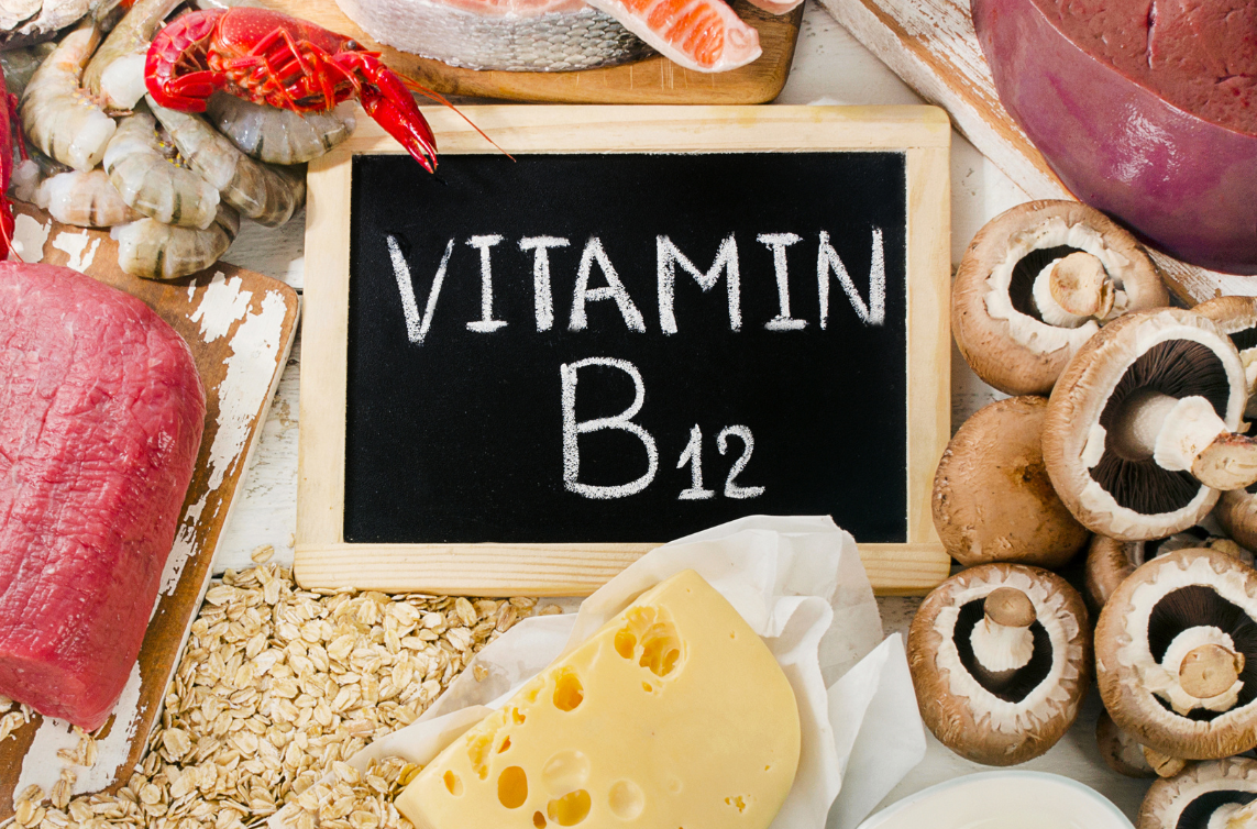 words vitamin b12 on chalkboard surrounded by meats, seafood, oats cheese, mushrooms