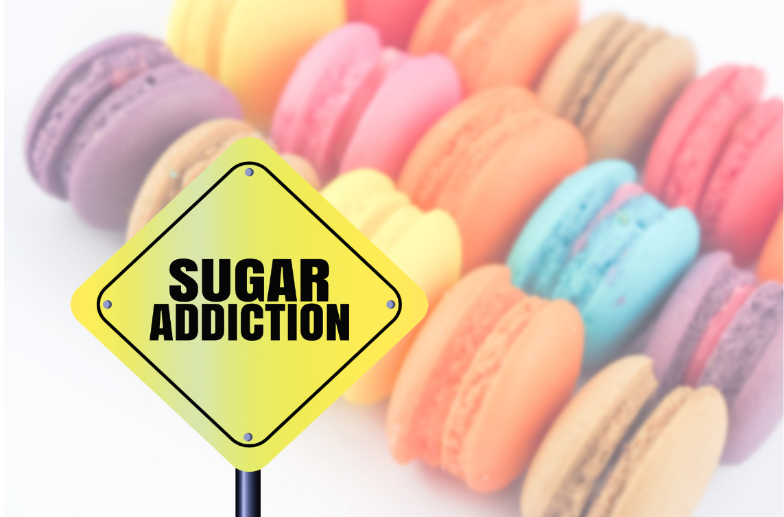 sign saying sugar addiction beside a bunch of colorful sweets