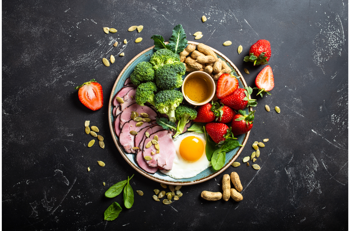 plate full of healthy foods including broccoli, eggs, strawberries and nuts
